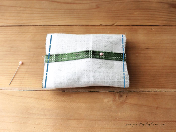 A wrapped diy hand warmer with marking to show placement of the seams for instruction.