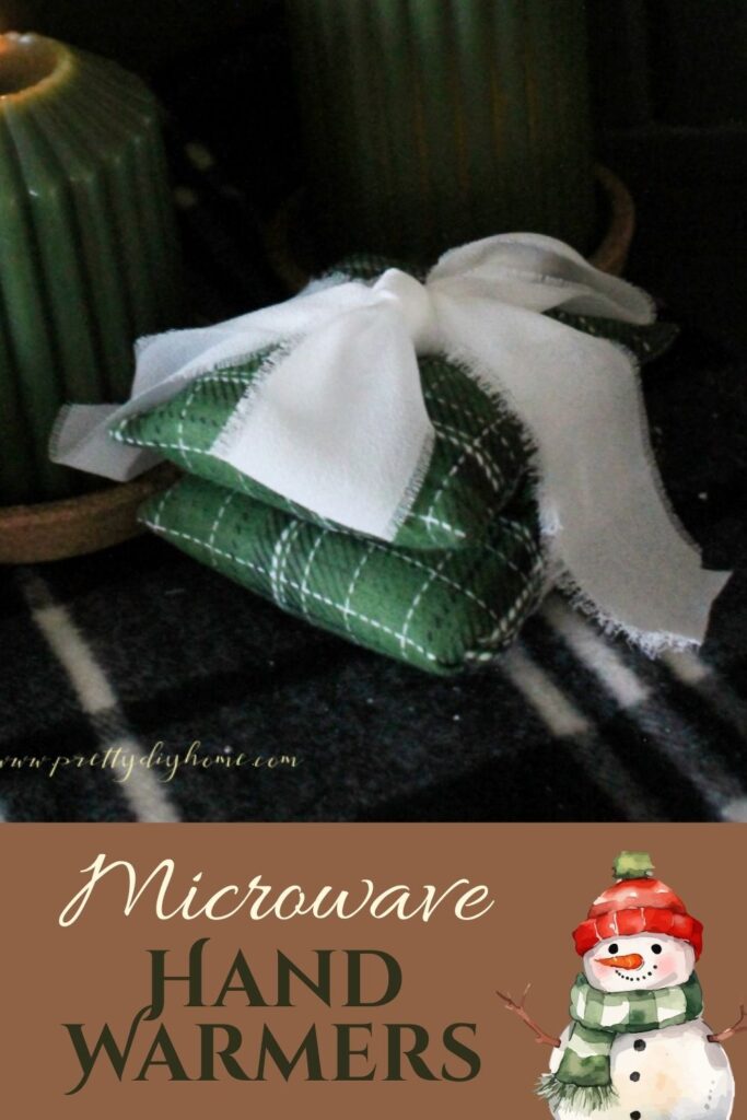 Two dark tartan green DIY hand warmers wwith a bright white Christmas bow.  Easy to sew microwave handwarmers diy for Christmas gifting.