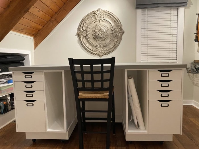 A DIY craft table with drawers on both side, and you can see newly built wall shelve of the craft room.