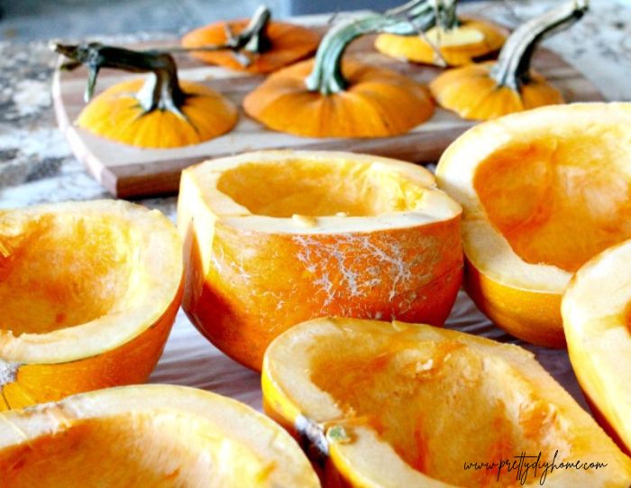 A parchment lined baking sheet covered with fresh pumpkins ready for baking,