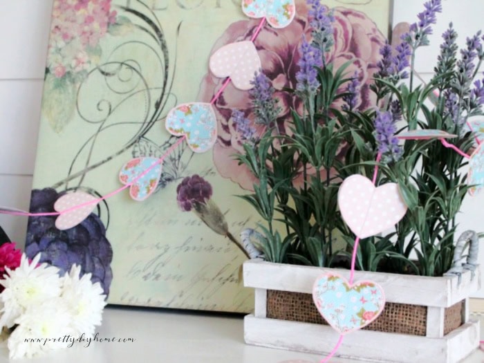 Finished free printable Valentine banner hanging in a romantic French style vignette with lavender and florals.