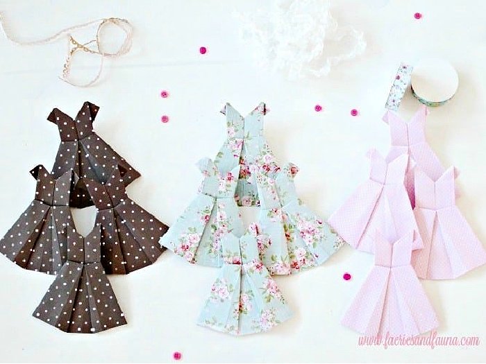 Six folded paper dresses.  The paper dresses are all folded and lined up before being added to a Spring craft idea.