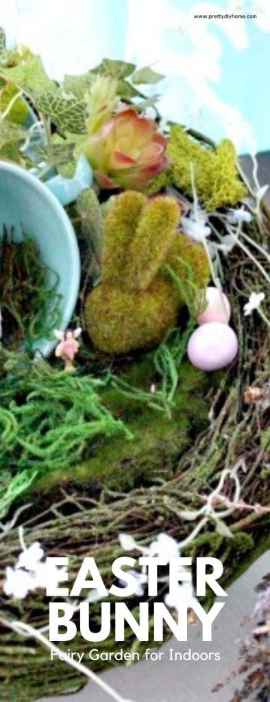 An moss covered Easter Bunny and tea cup sitting on a faux birdnest surrounded by Easter eggs for a DIY Easter Bunny fairy garden idea for indoors.