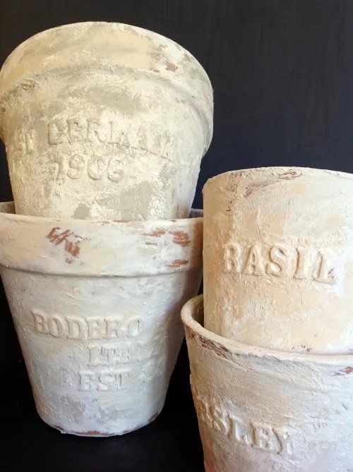 Four embossed and distressed terra cotta pots,  The pots are very vintage looking and have herb label embossed on the outside.