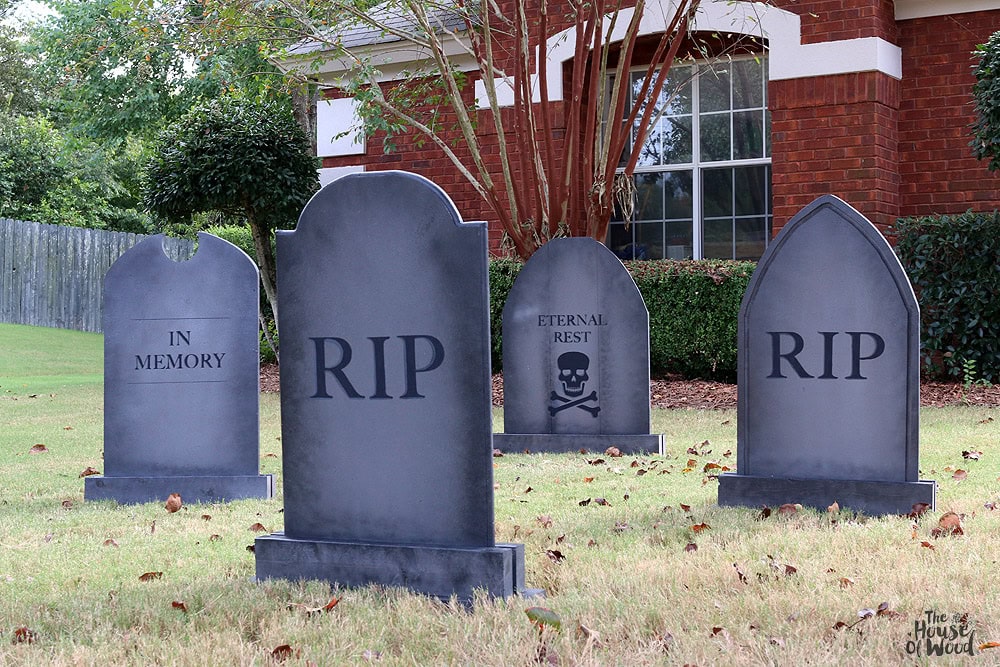 A Halloween graveyard with four very large a striking DIY wood gravestones.