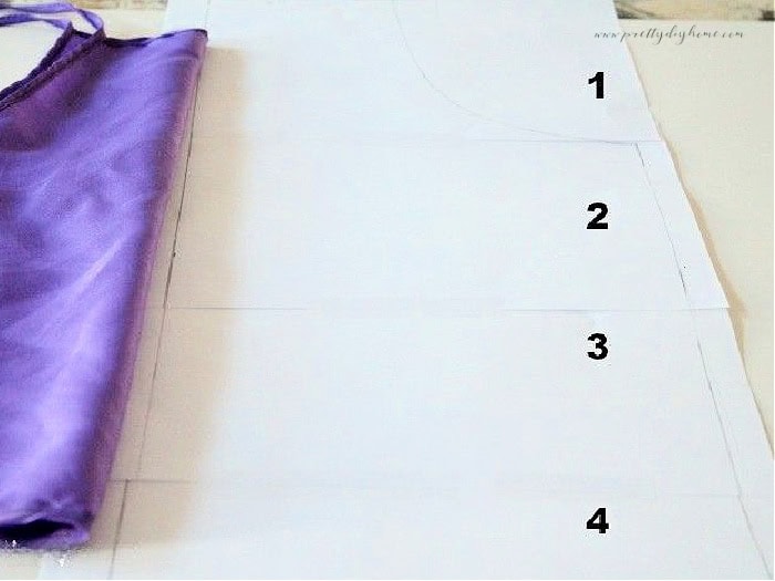 Printed apron pattern pages arranged on a table ready to cut for a handmade children’s apron sewing project