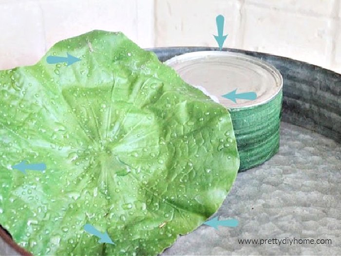 Building the layers of a indoor fairy garden using a large leaf and hot glue.