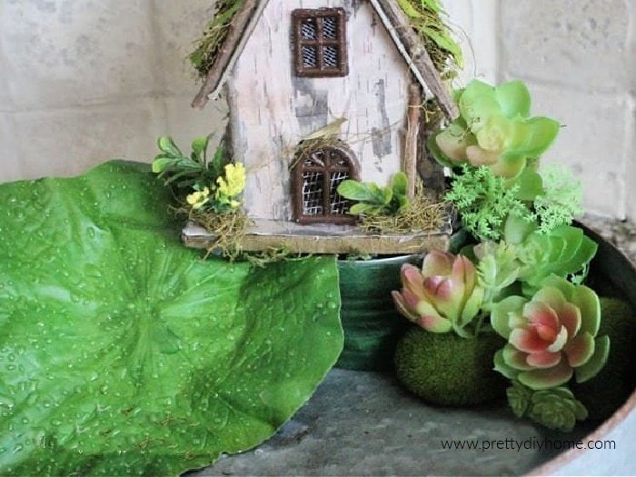 Placing a fairy house onto a diy balcony while making a miniature fairy garden for indoors.