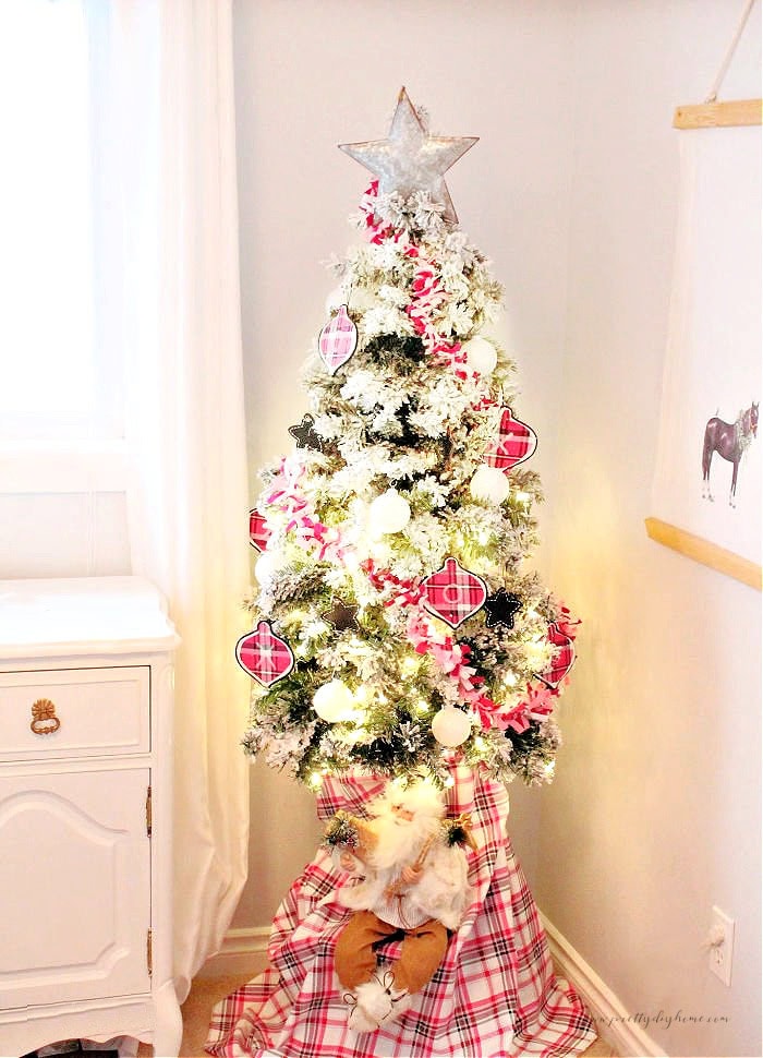 Pink Christmas tree decorated with a DIY fabric garland, matching tree skirt and silver star toppers in a little gir's Christmas bedroom corner.