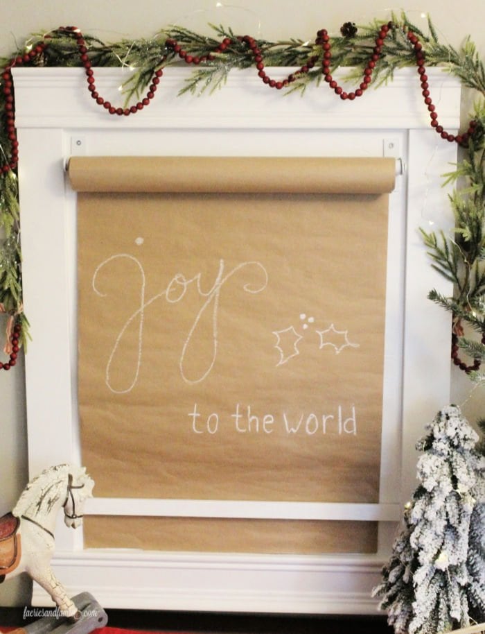 A DIY paper scroll sign with Christmas lettering and a DIY paper roll holder.