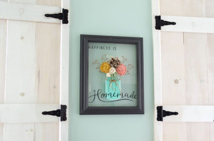 A thrift store DIY picture frame craft idea with a thrift store frame and stenciled artwork on glass.