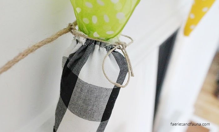 Tying DIY fabric carrots to twine to make a Easter Banner