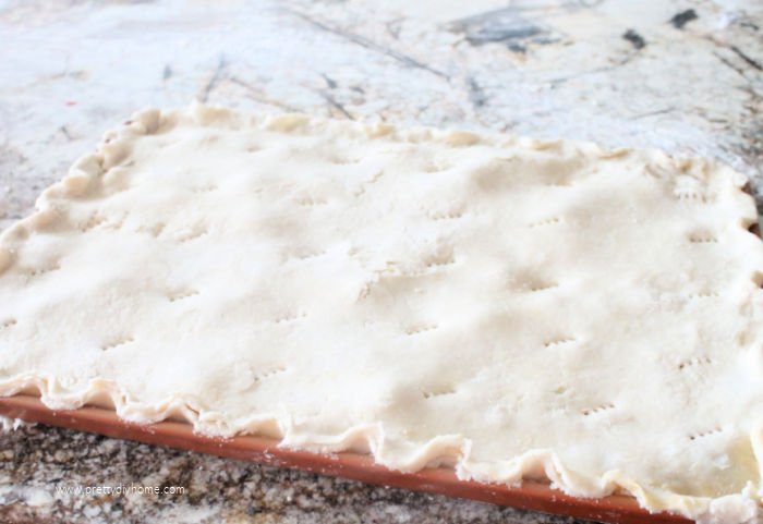 An unbaked large homemade bumbleberry slab pie from scratch