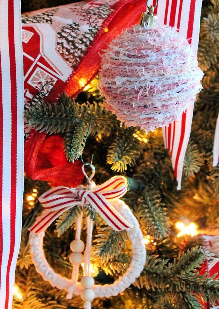 Two different DIY farmhouse Christmas ornaments hanging on a decorated Christmas Tree.