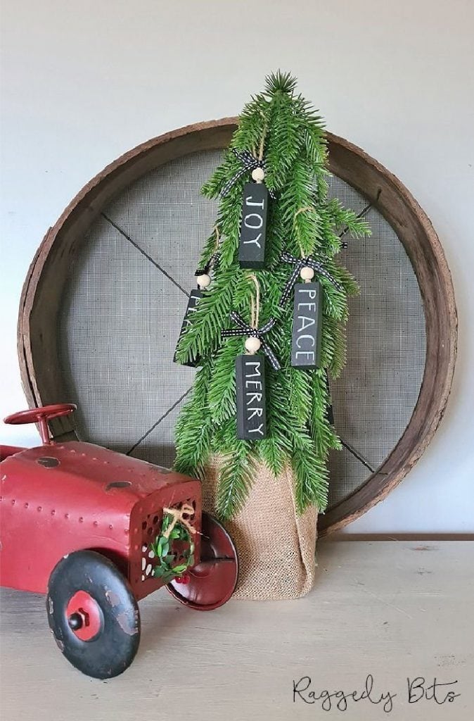 DIY Black and White Christmas Decorations hanging on a miniature tree with a vintage red truck.