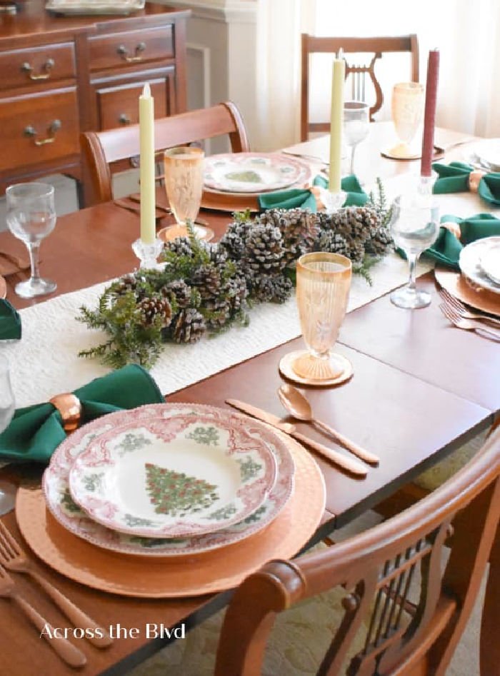 Traditional Christmas table setting with vintage Christmas plates and peach goblets.