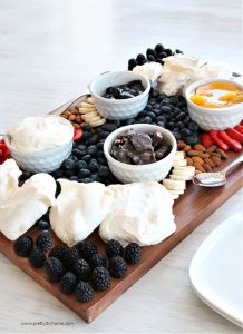 Pavlova grazing platter with mini pavlova, fresh fruit and whipping cream, along with assorted toppings like chocolate.