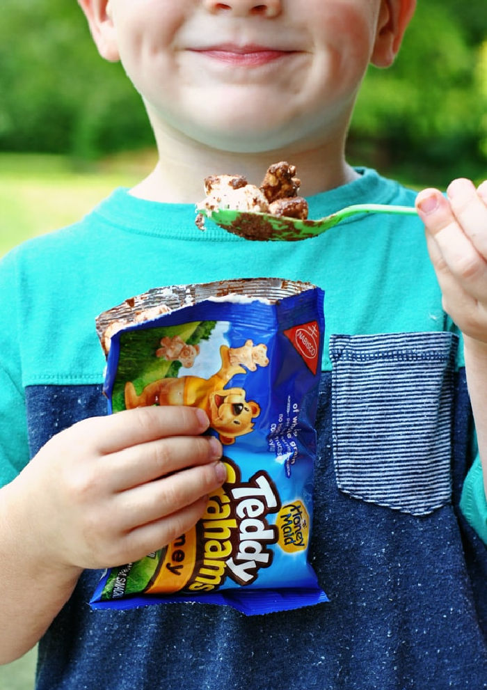 A little boy with a big smile holding a bag full of less mess s'mores recipe.