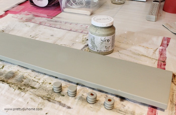 Painting a piece of scrap wood with eucalyptus 