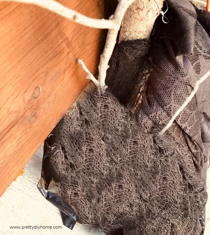 The base of a DIY Halloween tree, covered in black fabric for camoflage.