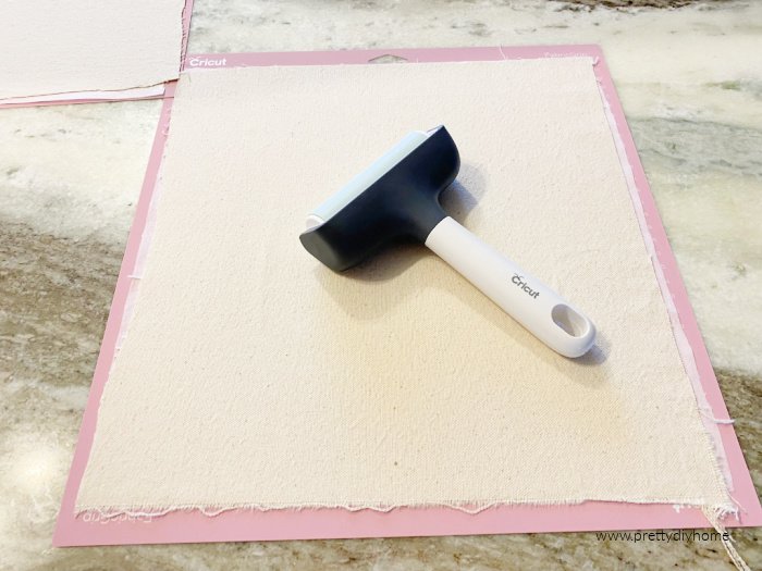 Using a brayer to attach fabric to a fabric Cricut mat.