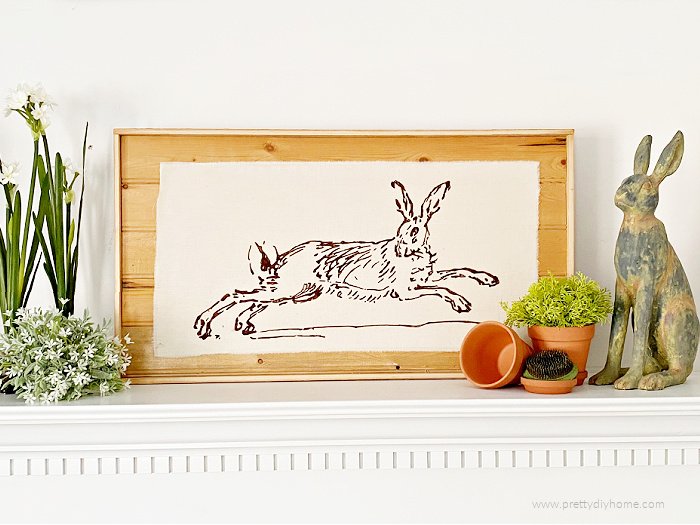 Vintage rabbit illustration placed on DIY wood frame for inexpensive Spring or Easter mantel decor.