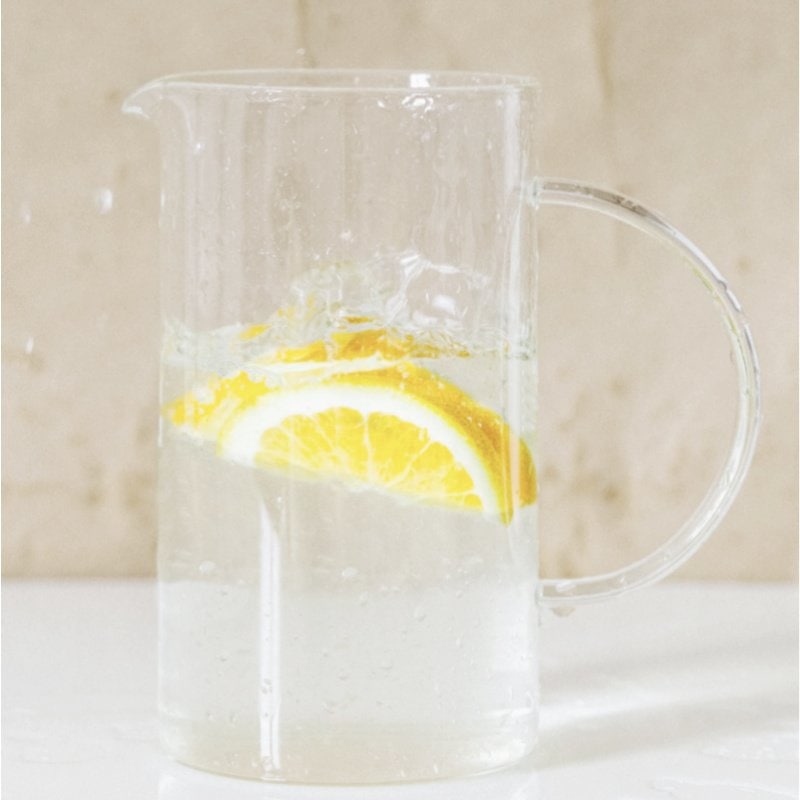 A tall glass picture filled with simple syrup, water, lemon and vodka