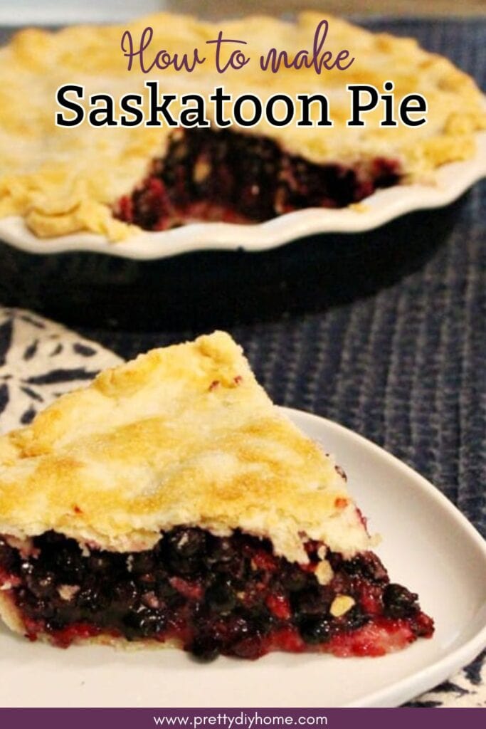 Slice of Saskatoon berry pie in the foreground with a full pie in the background showing the thick berry filling