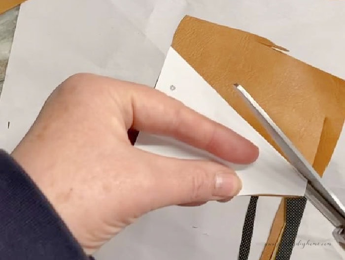 Cutting out new rocking horse ears using a paper template and scrap leather.
