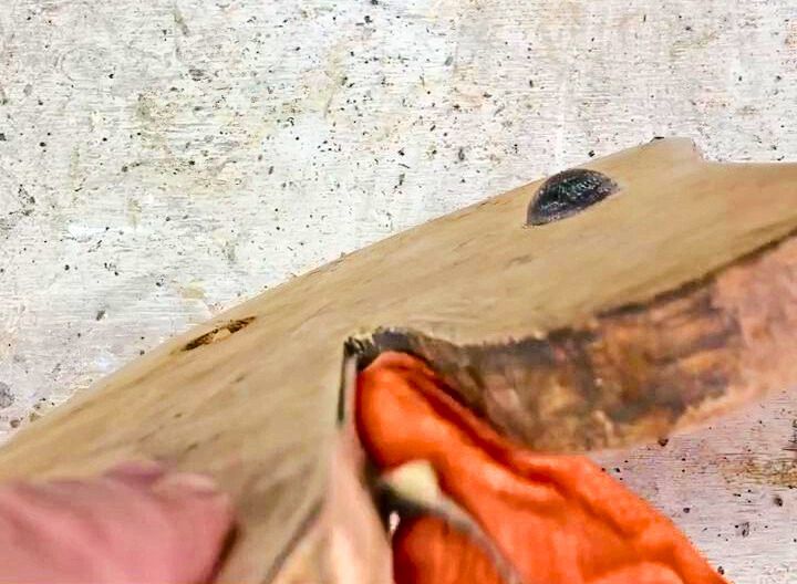 Sanding the tight spaces of a rocking horse with sandpaper.