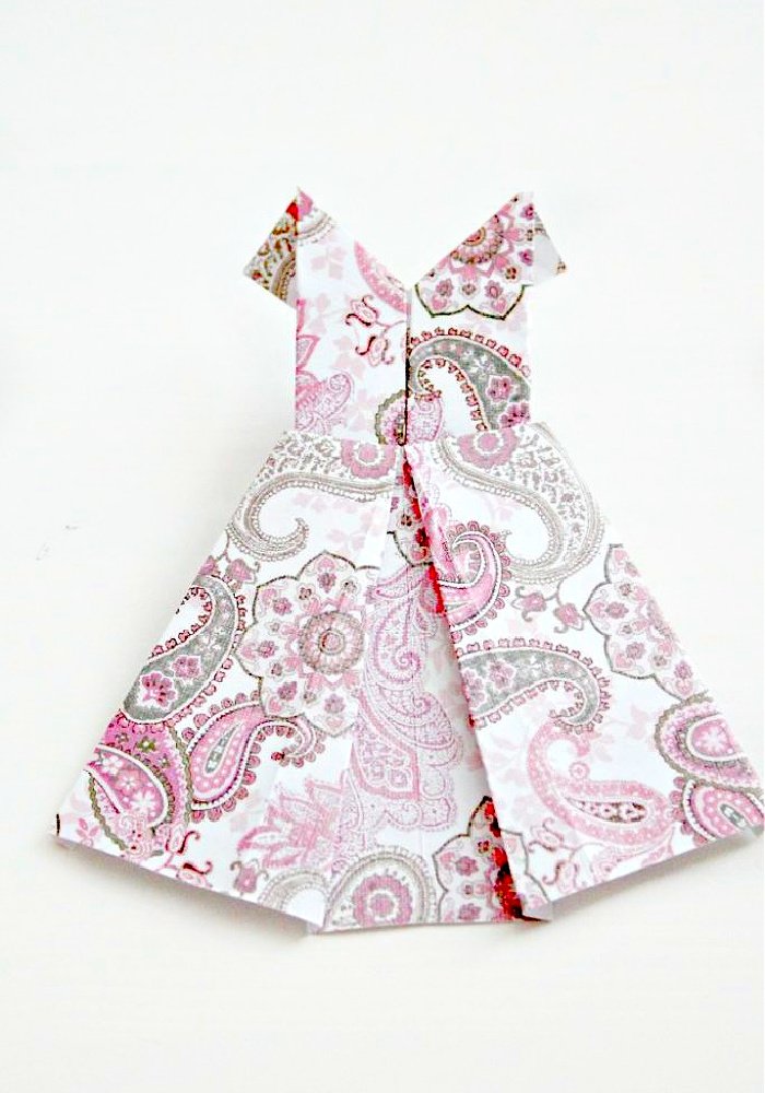 A folded paper dress, easy paper craft. The completed origami paper dress is in soft pink colours has not been added to the banner yet. You see the complete paper dress diy.