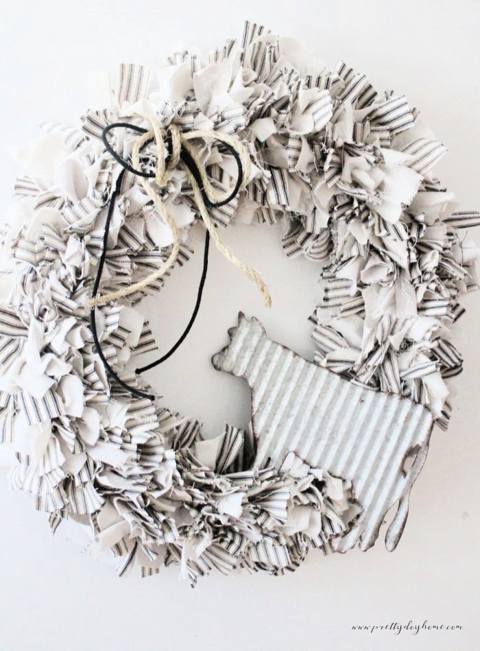 A neutral rag wreath craft in soft creams and greys this version is decorated with a galvanized cow and twine bow.