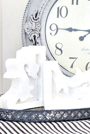 Two DIY Wooden Corbels in white with a farmhouse clock in the background.