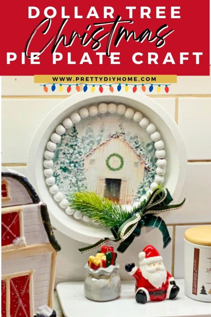 A dollar tree christmas craft diy made with a pie plate, free printable, and green tartan ribbon.  There are four different printables to choose from including this white sparkling barn,