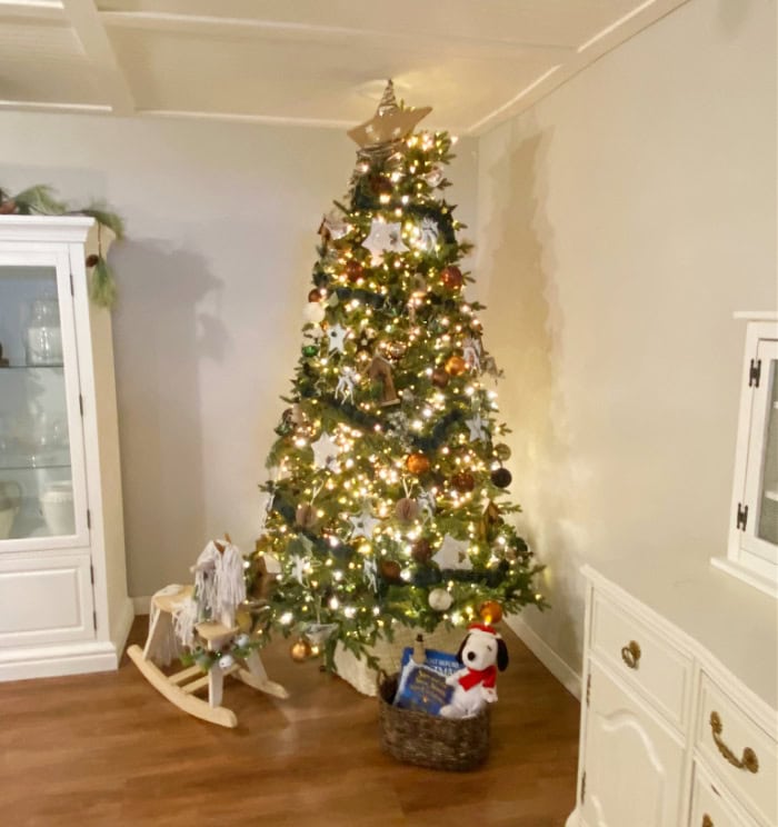 A Christmas tree decorated with green plaid fabric Christmas garland. You can see the garland wrapped around the Christmas tree.