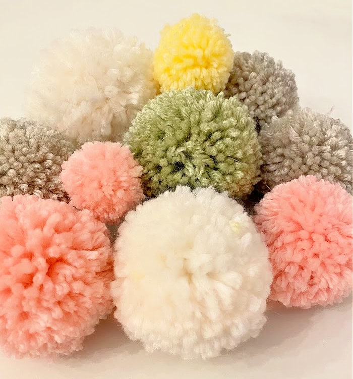 A stack of pastel colored pom poms made for adding to an Easter wreath.