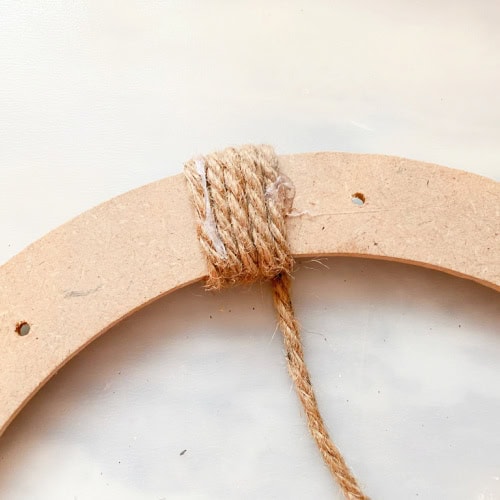 The back of a wreath form with wrapped around twine thats been glued in place to hold.