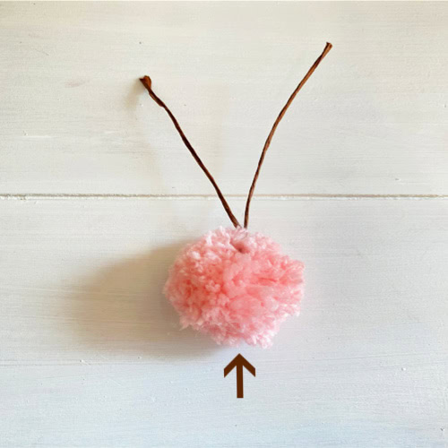 How to insert wire inside a pom pom to form wire Easter bunny ears, as part of a pom pom Easter bunny craft.