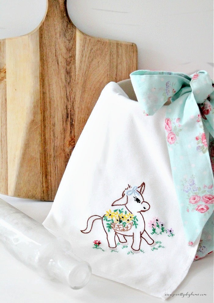 A DIY apron with a vintage vibe made using tea towels with a sweet embroidered donkey in the corner.