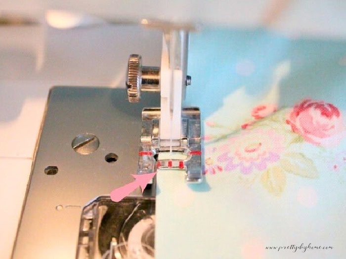 Sewing a topstitch along the edge of a apron tie with a sewing machine.