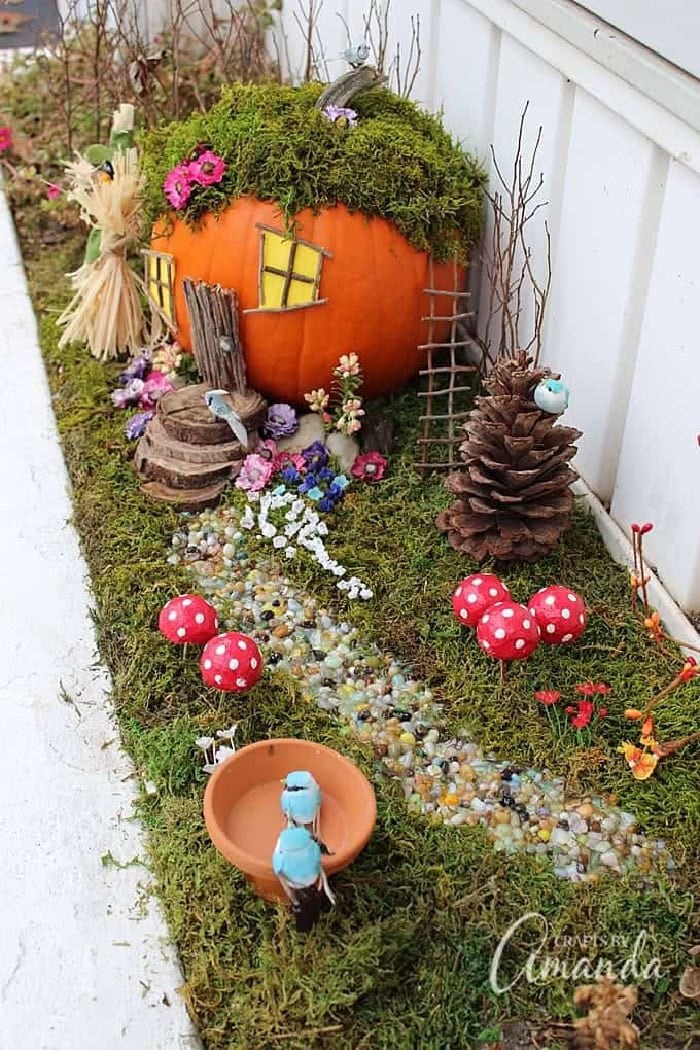 A fairy garden featuring a fun and pretty fairy house made out of a pumpkin.