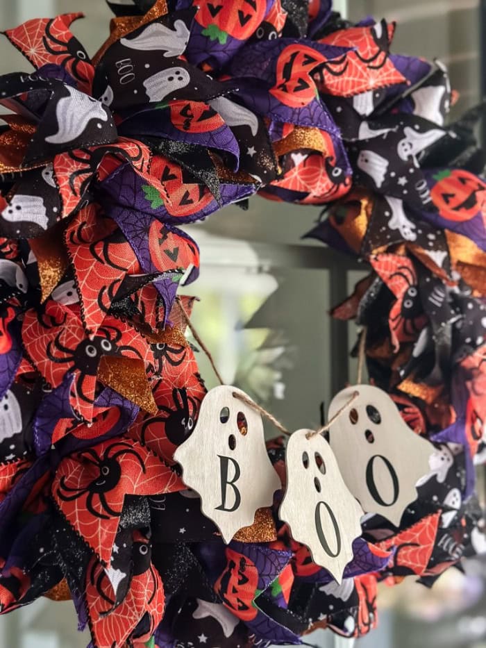 A large and full Halloween wreath made with Halloween colored ribbon and Dollar Tree Ghosts.