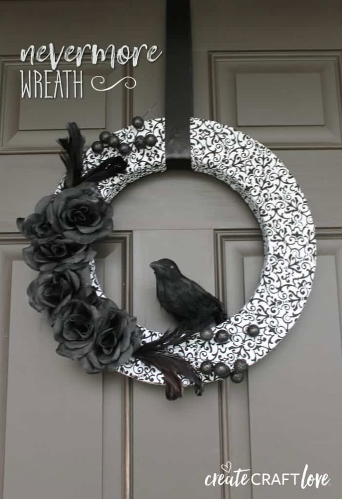 An elegant black and white wreath with black flowers and a crow.  Its nevermore themed for Halloween.