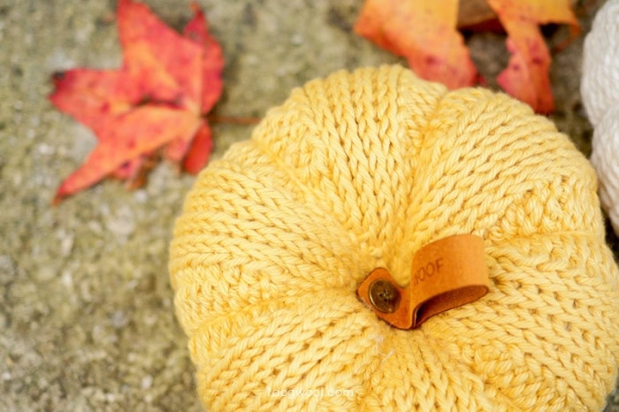 A soft yellow handmade DIY pumpkin created using tunisian crochet.