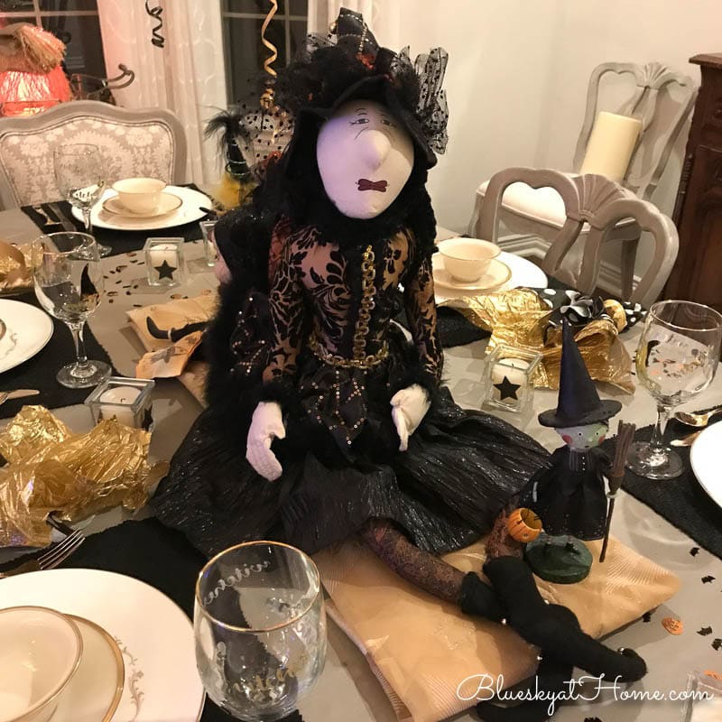 An elegant yet fun Halloween centerpiece of a sparkling witch. The centerpiece is part of an elaborate tablescape.