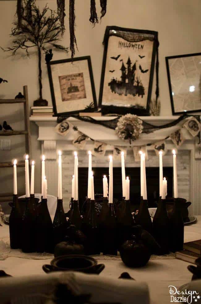 An inexpensive but striking Halloween centerpiece consisting of a 20 bottles painted black with white candles all lit.