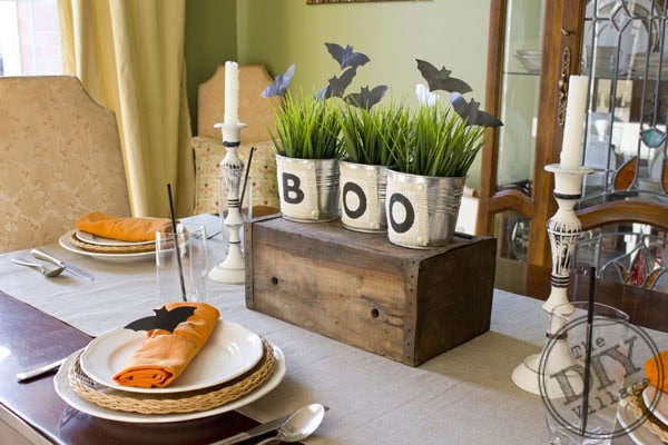 Three silver buckets filled with grass. The buckets each have a etter that spells out BOO.