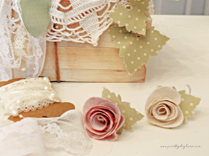 Two homemade fabric flower roses being put together for a diy pumpkin.