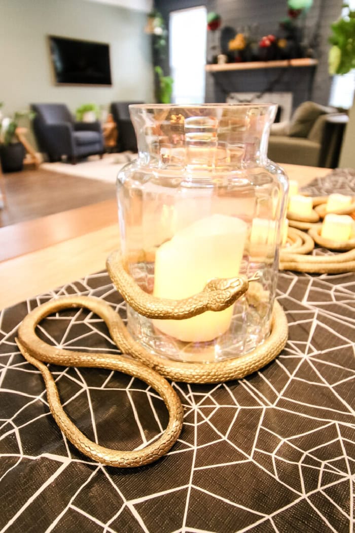 An  elegant and very creepy Halloween centerpiece featuring various gold snakes wrapped around candles.