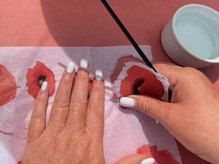 Carefully wripping out a paper printed transfer of a poppy to achieve soft edges.